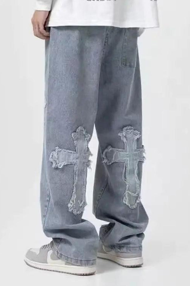Light blue jeans with cross designs on a white background