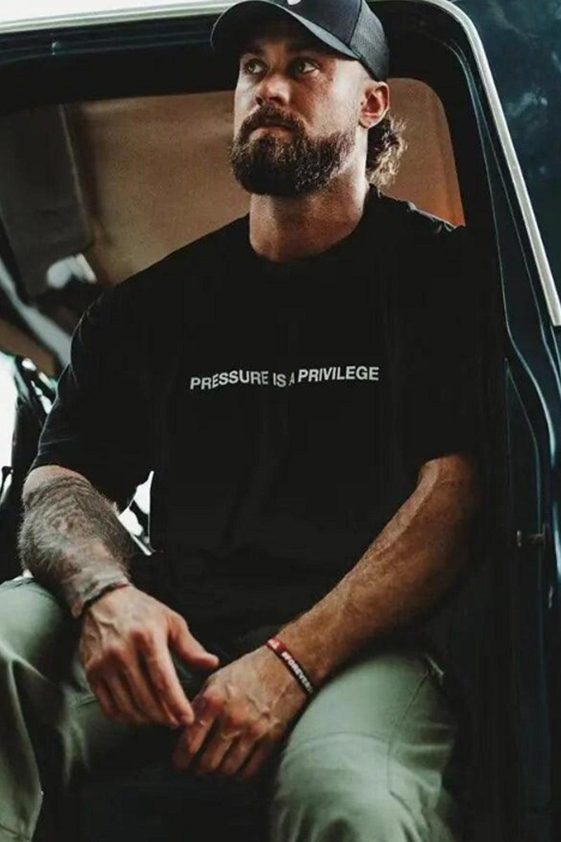 Pump cover with 'Pressure is a Privilege' text, featuring an oversized fit for comfort and style during workouts.