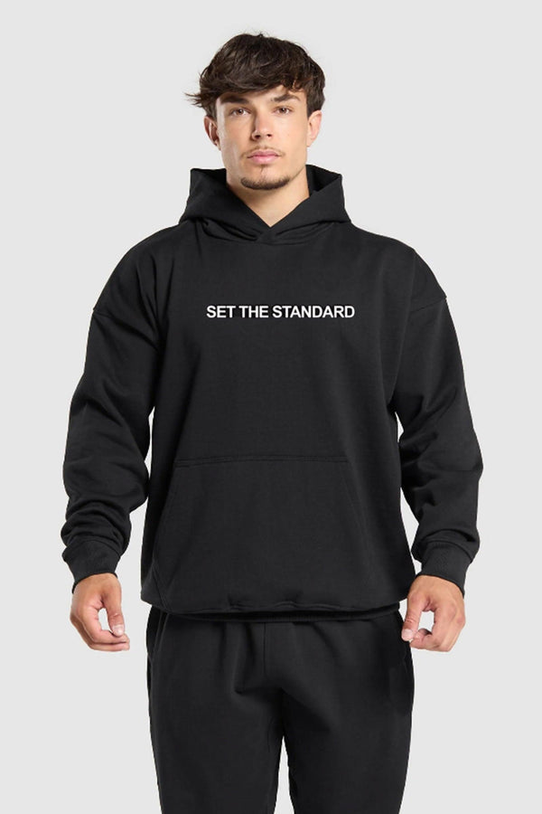 Oversized hoodie featuring 'Set the Standard' text, designed for comfort and style with a relaxed fit and adjustable drawstring hood.